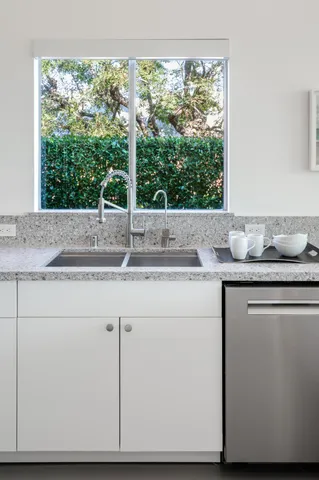 a kitchen with a window sink and cabinets