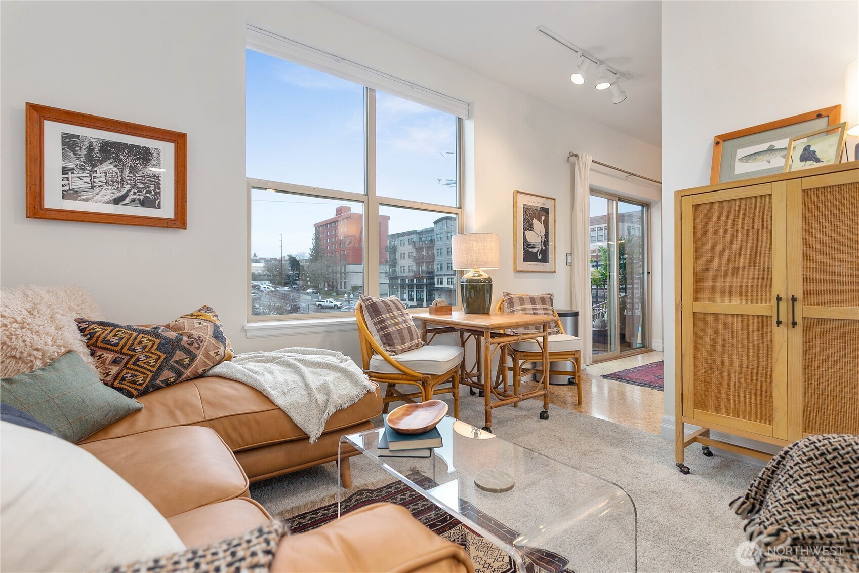a living room with furniture large window and wooden floor