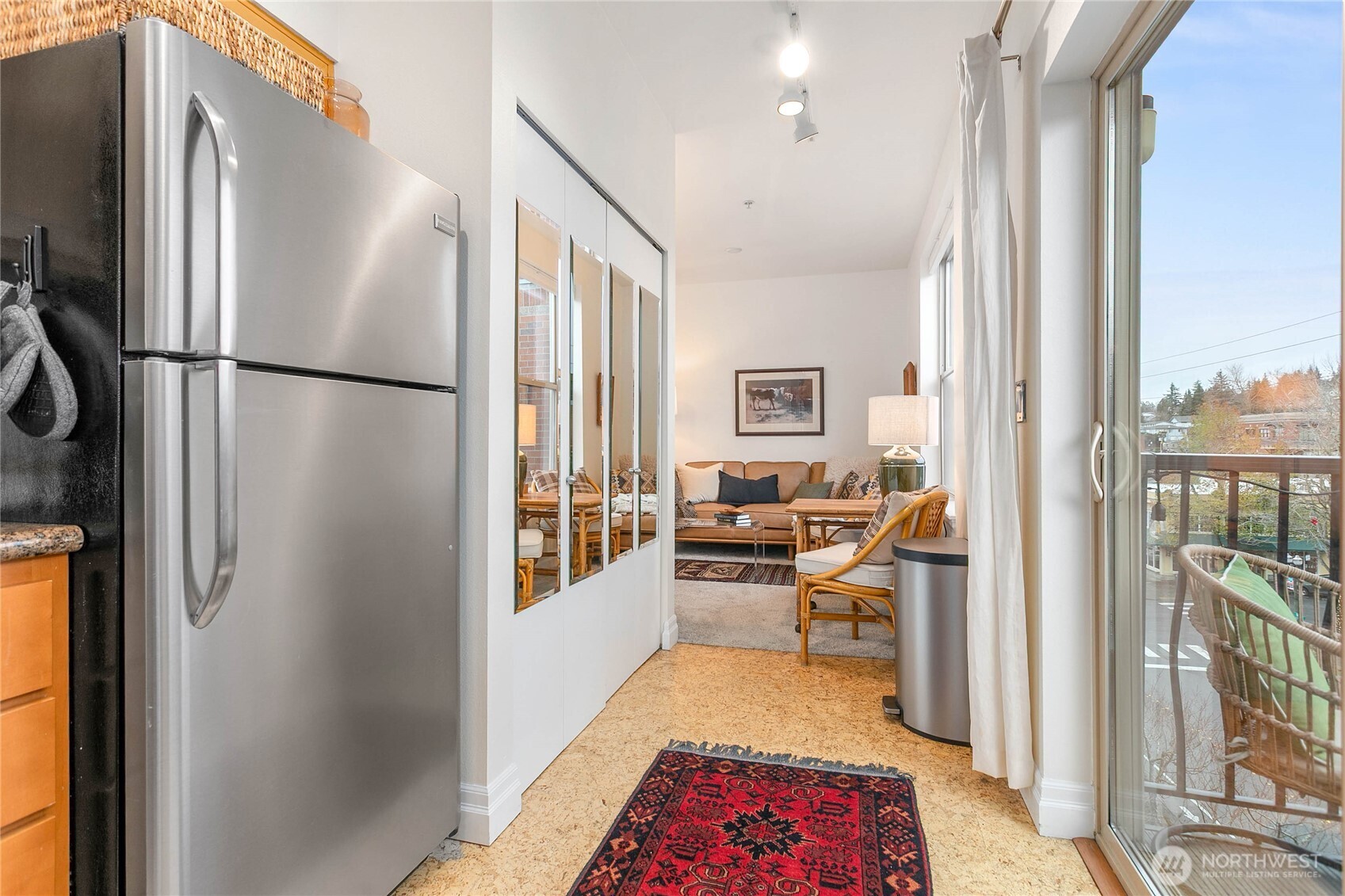 1310 10th Street, Unit 408 Bellingham, WA 98225 - Photo 16 of 33 a hallway with a couch and a dining table with wooden floor