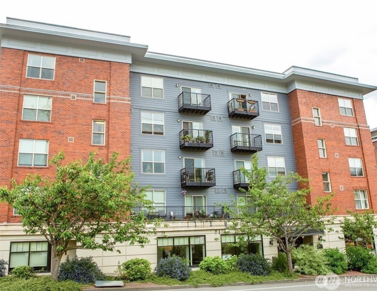 1310 10th Street, Unit 408 Bellingham, WA 98225 - Photo 7 of 33 a front view of a building with lot of plants and seating