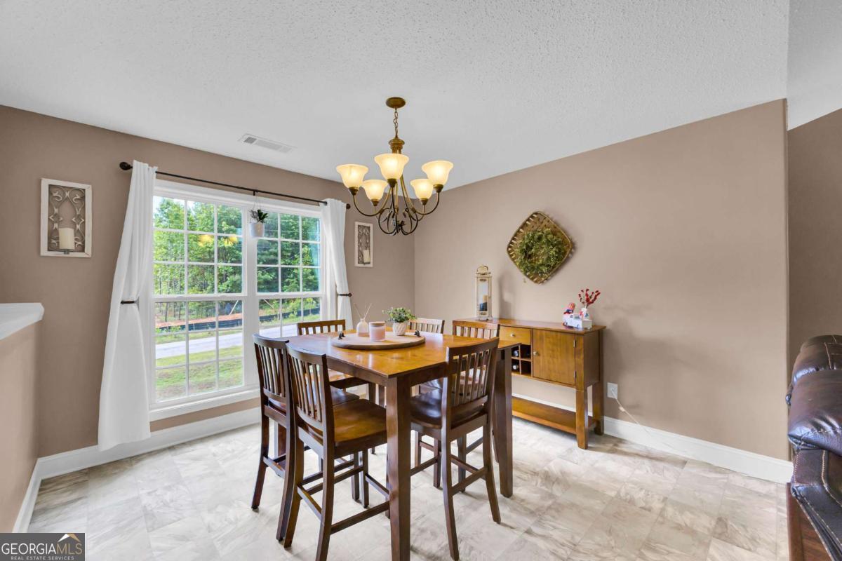 335 Elizabeth Court Colbert, GA 30628 - Photo 9 of 33 a dining room with furniture a rug and a chandelier