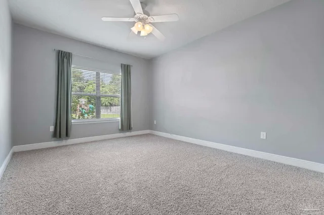 an empty room with a window and a fan