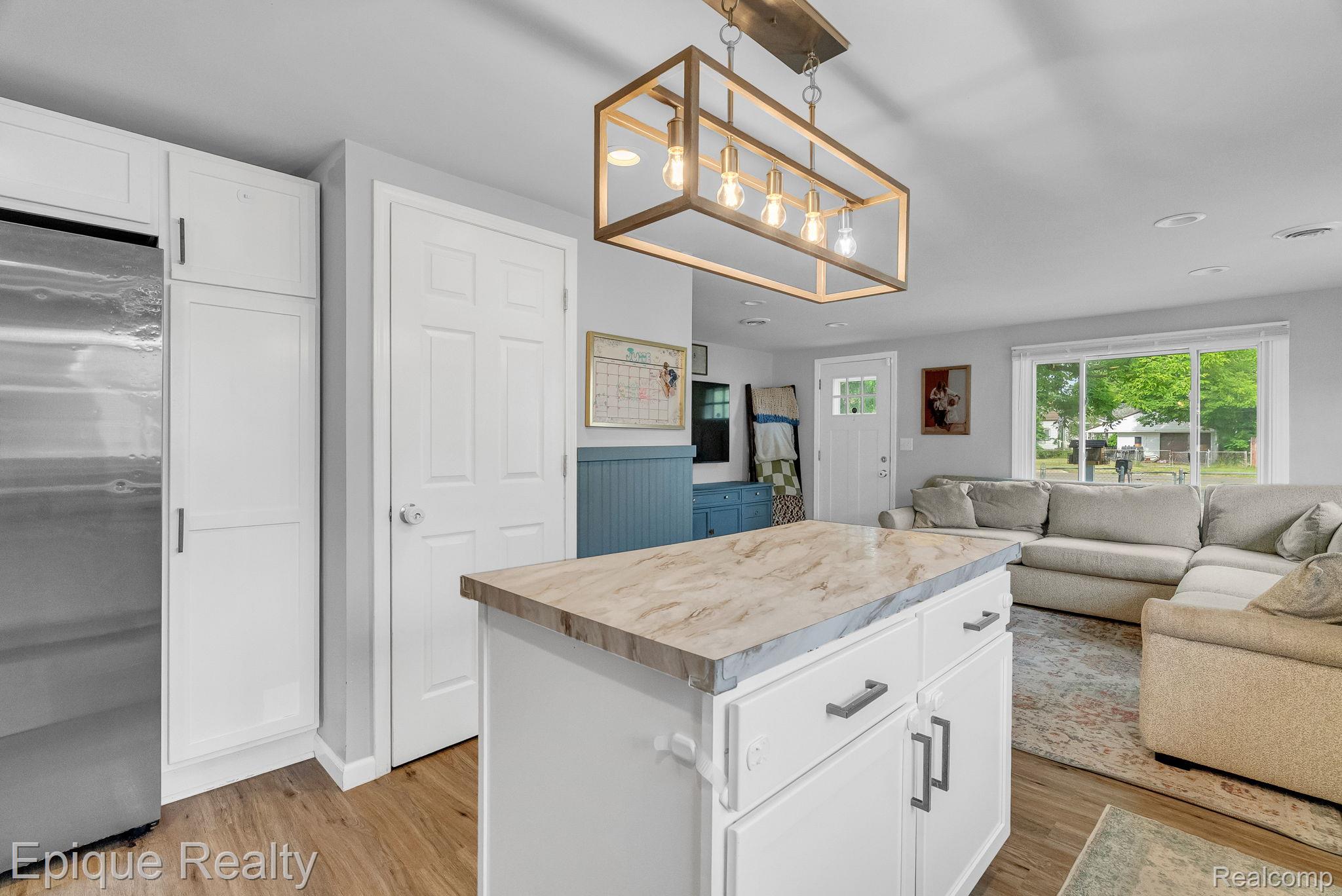 2182 North Center Road Burton, MI 48509 - Photo 15 of 34 Kitchen island featuring a stone-finish countertop and white cabinetry with dark hardware