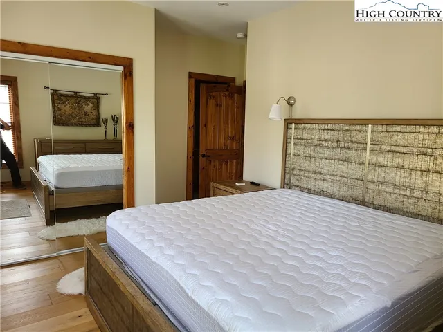 a bedroom with a bed and a flat tv screen on dresser