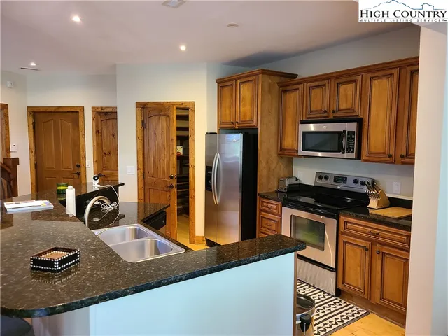 a kitchen with stainless steel appliances granite countertop a sink stove and refrigerator