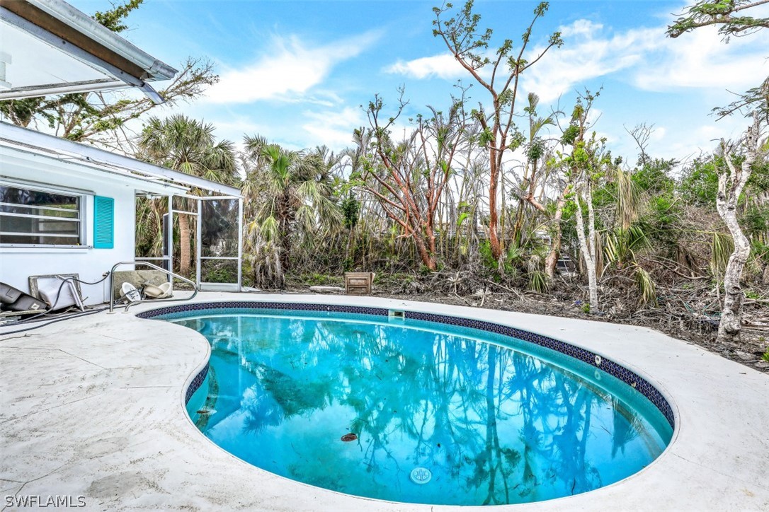 591 Boulder Drive Sanibel, FL 33957 - Photo 26 of 29 a swimming pool with outdoor seating and plants