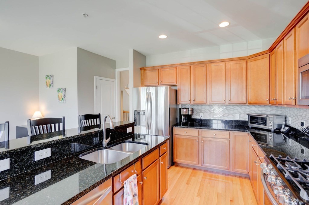 31 Jacob Way, Unit 31 Reading, MA 01867 - Photo 18 of 42 a kitchen with granite countertop lots of counter top space and stainless steel appliances