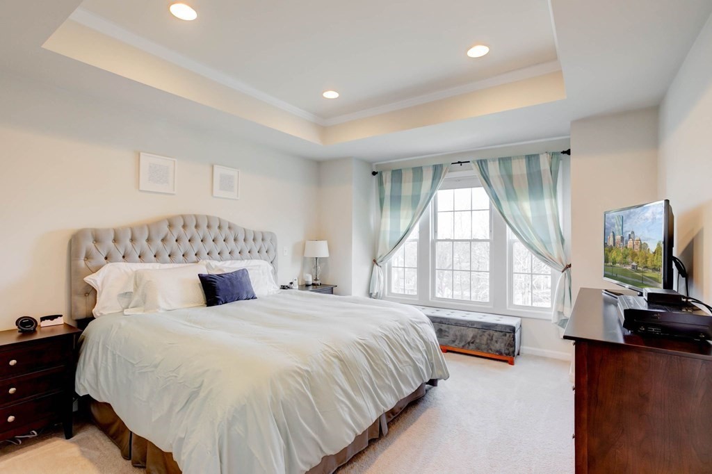 31 Jacob Way, Unit 31 Reading, MA 01867 - Photo 24 of 42 a spacious bedroom with a bed and a flat tv screen on dresser