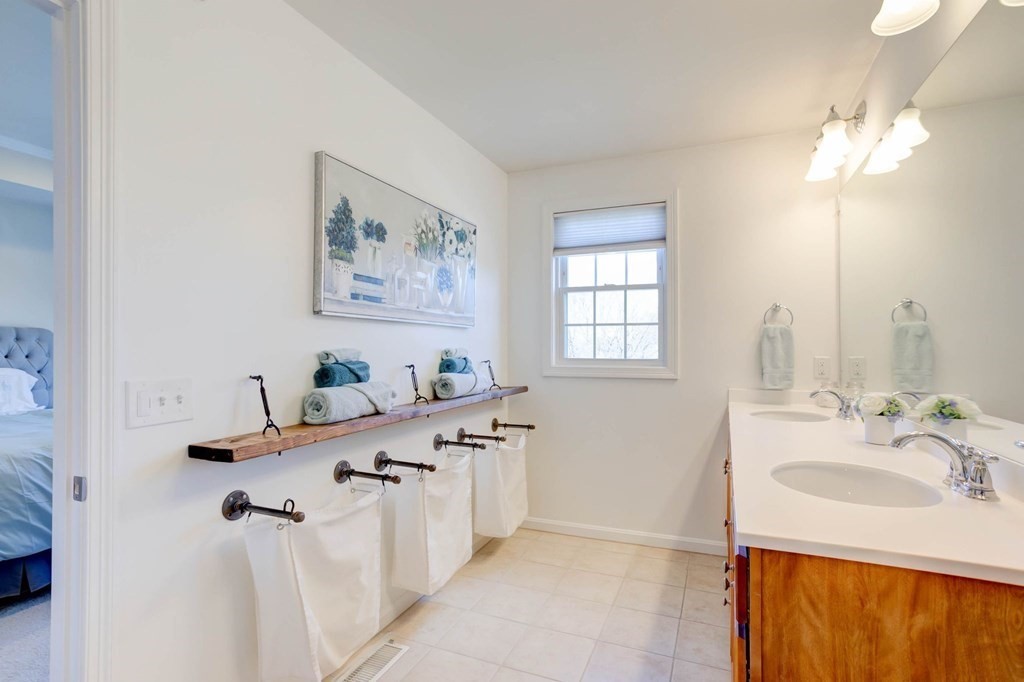 31 Jacob Way, Unit 31 Reading, MA 01867 - Photo 29 of 42 a bathroom with a granite countertop sink a mirror a vanity and a bathtub