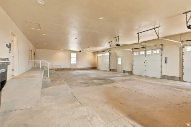 580 North 300 East Logan, UT 84321 - Photo 36 of 74 Spacious multi-car garage featuring multiple overhead doors with windows, ample interior lighting, a built-in access ramp with handrail, and a window for natural light