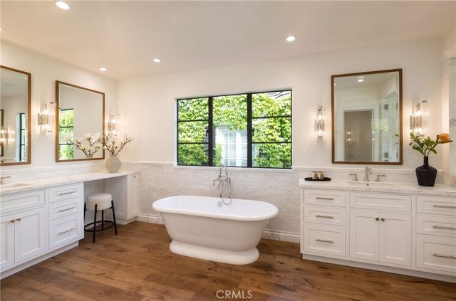 a bathroom with a double vanity sink a mirror and a bathtub