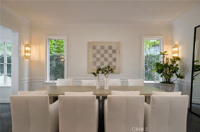 a dining room with furniture and large windows