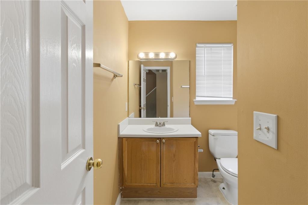 1081 Estes Drive Southwest, Unit 504 Atlanta, GA 30310 - Photo 20 of 32 a bathroom with a granite countertop sink a toilet and a mirror
