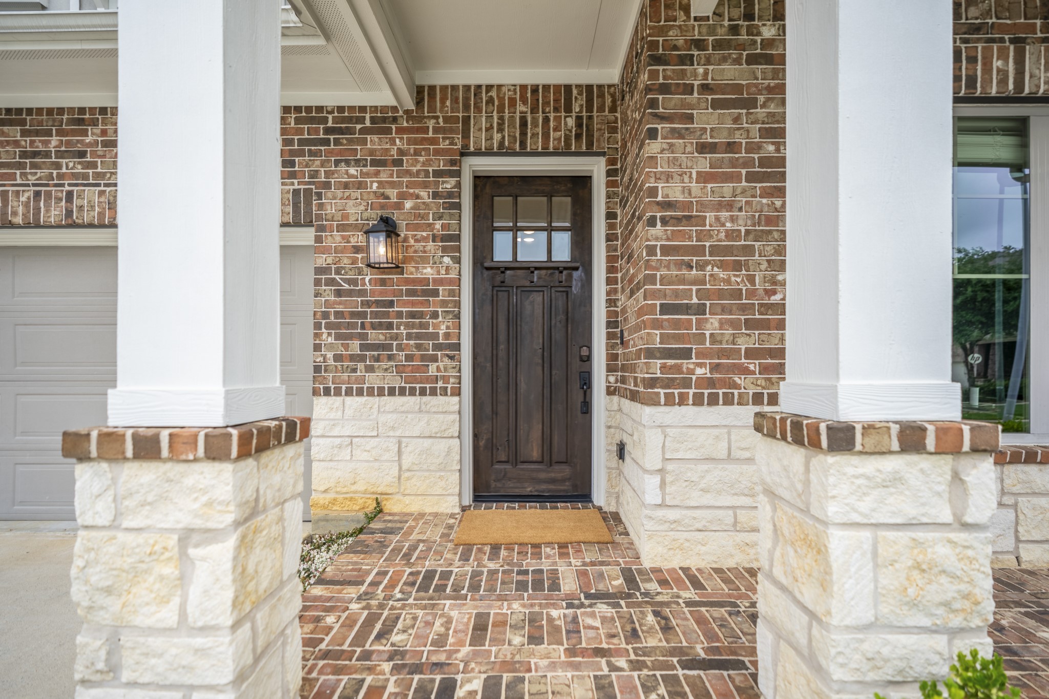 7502 Windsor Park Court Spring, TX 77379 - Photo 3 of 50 Your tour begins here. Framed by the covered front porch and warm brick-and-stone details, the front entry sets a welcoming tone before opening to the light-filled living spaces beyond.