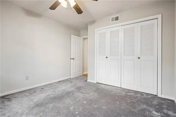 an empty room with chandelier fan
