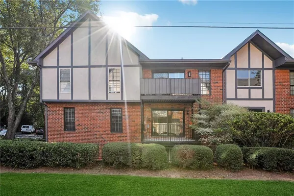 a view of a brick house next to a yard