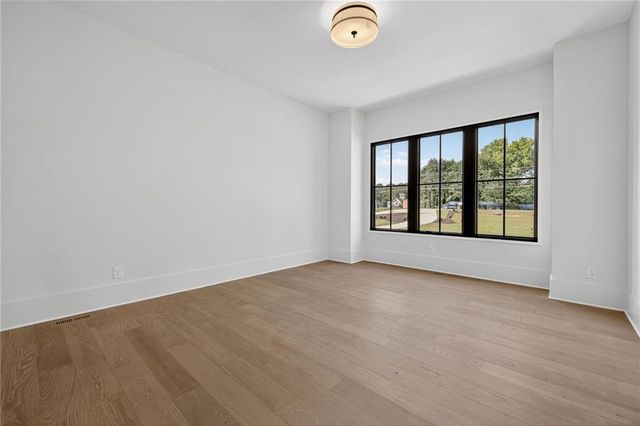 a white house with a big yard and large trees