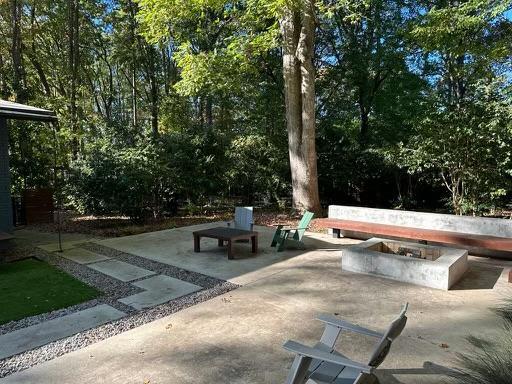 3322 Ocotea Street Raleigh, NC 27607 - Photo 30 of 34 a view of backyard with a table and chairs with a fire pit and a large tree