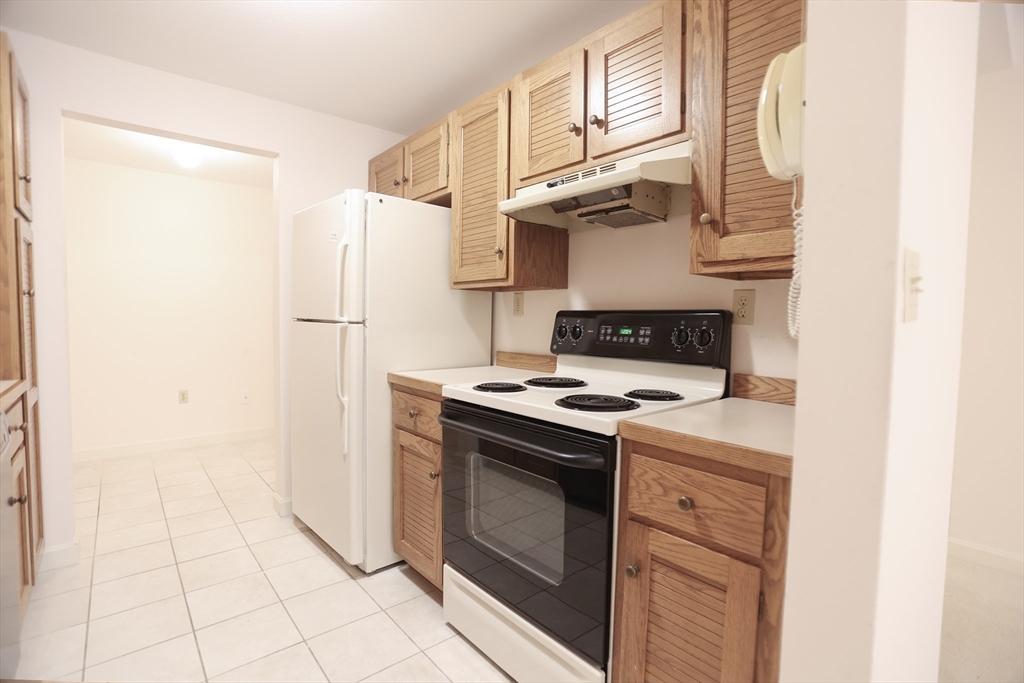 100 Keyes Road, Unit 220 Concord, MA 01742 - Photo 3 of 23 a kitchen with a stove and a refrigerator