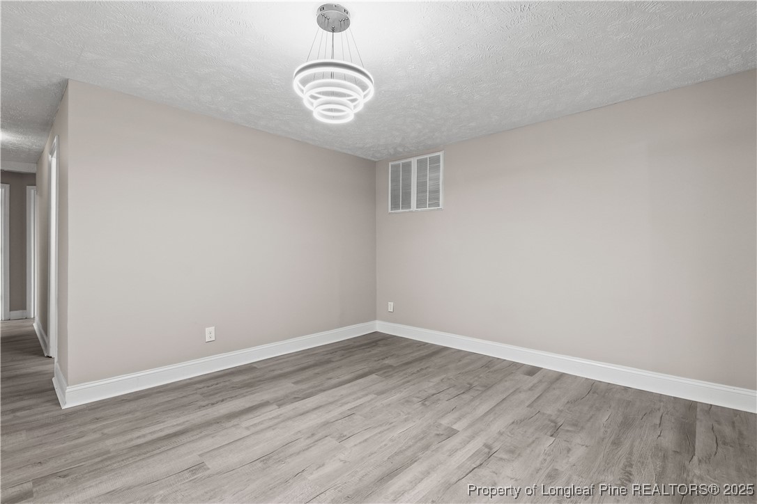 2302 Odom Road Hope Mills, NC 28348 - Photo 5 of 33 an empty room with wooden floor and windows