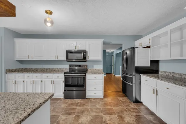 a large kitchen with cabinets appliances and a counter space