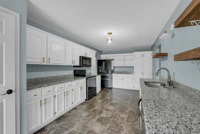 a kitchen with stainless steel appliances granite countertop a sink and cabinets