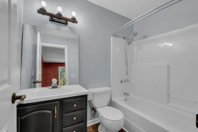 a bathroom with a granite countertop sink a toilet and shower