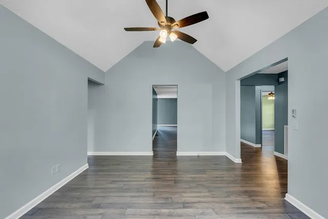 a view of empty room with wooden floor