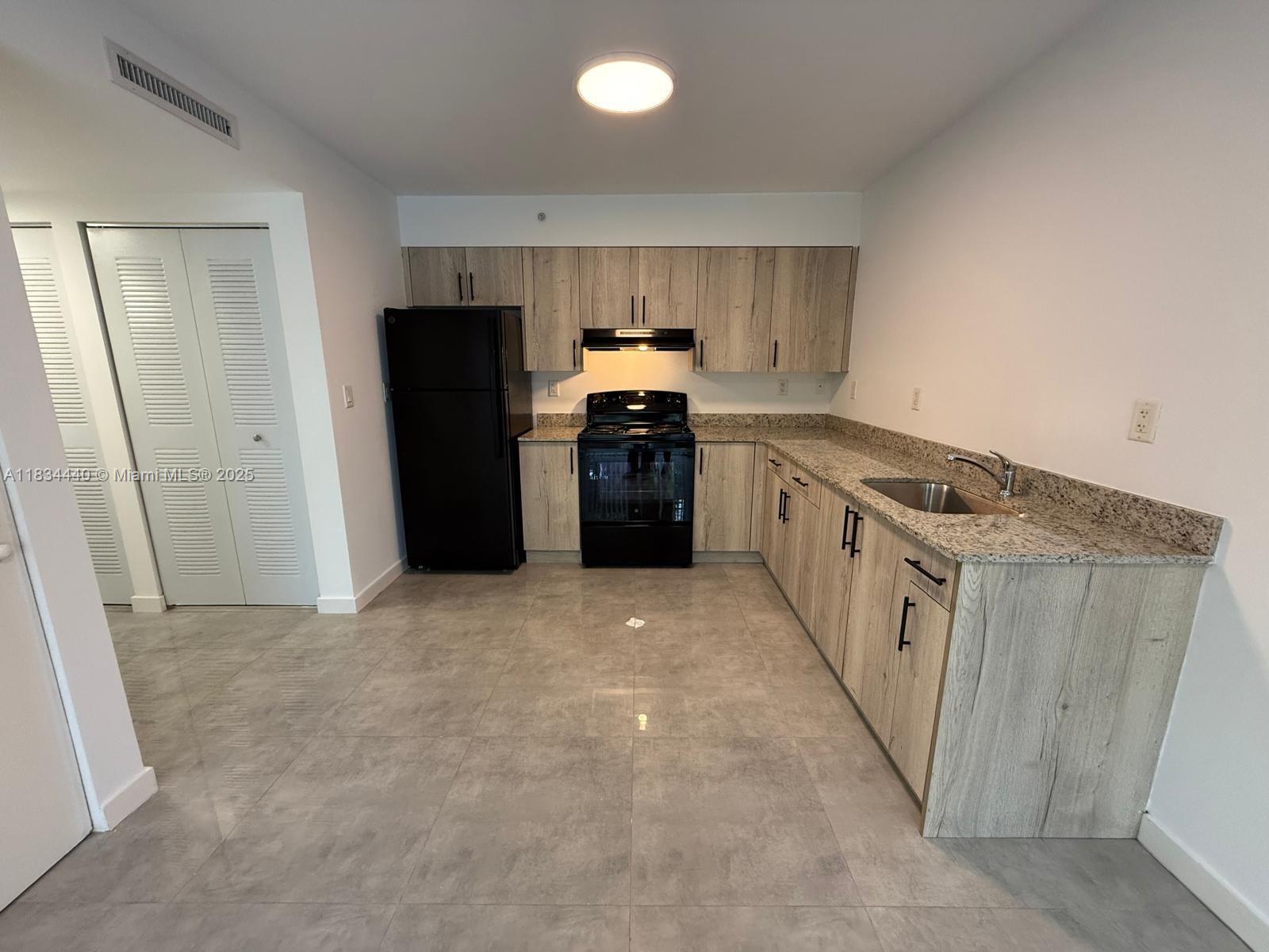 Golden Glades Miami, FL 33161 - Photo 3 of 11 a kitchen with granite countertop a refrigerator stove and sink
