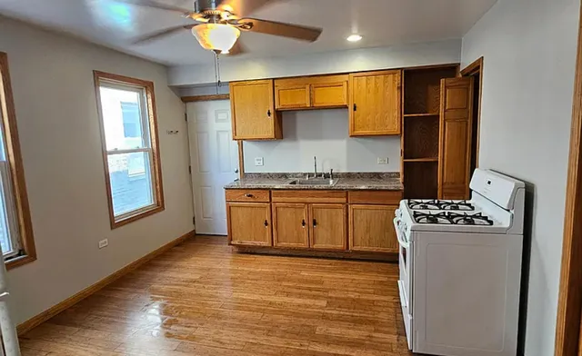 a kitchen with a stove cabinets and wooden floor