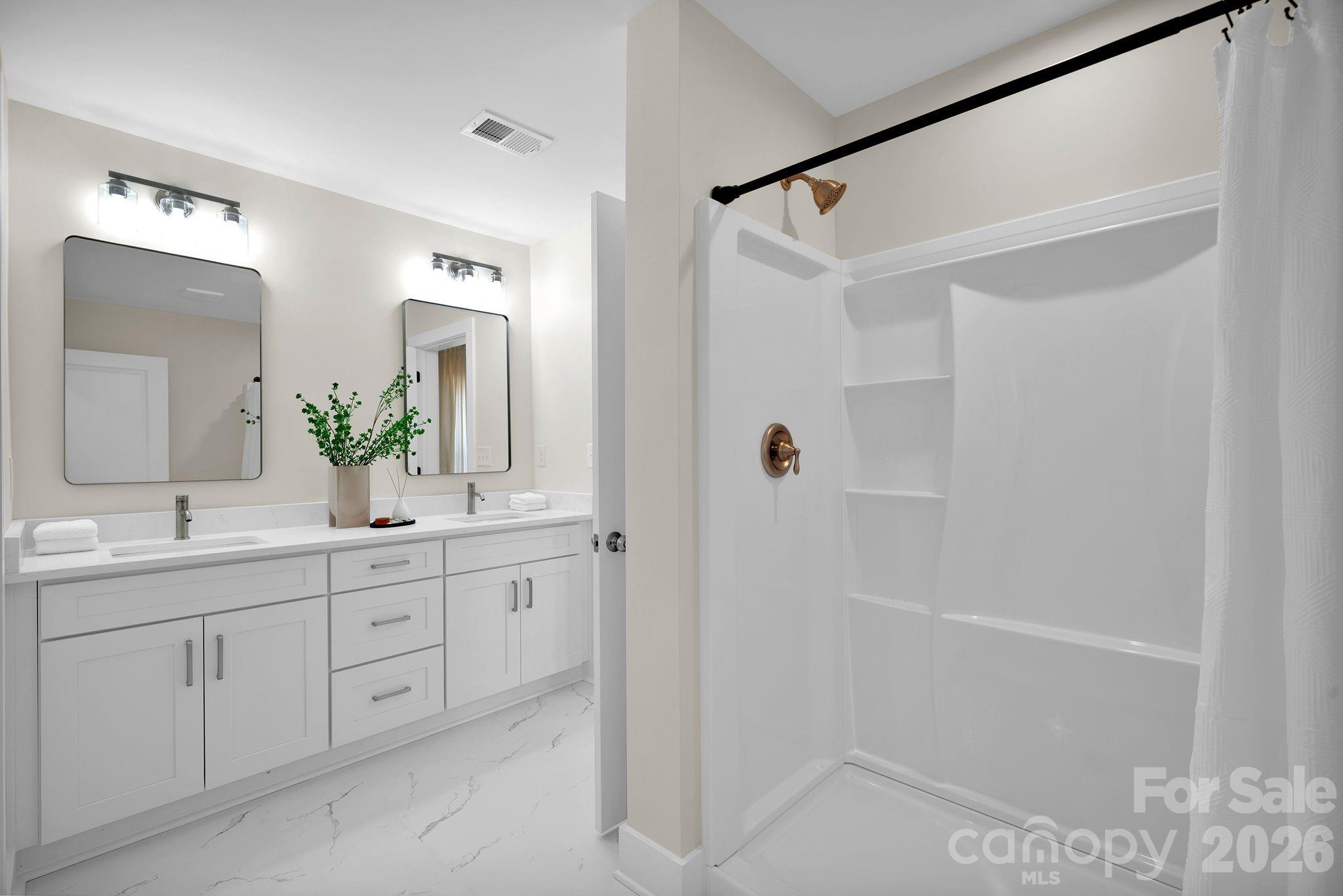 9052 Unity Church Road Mooresville, NC 28115 - Photo 20 of 32 a bathroom with a double vanity sink and mirror with shower