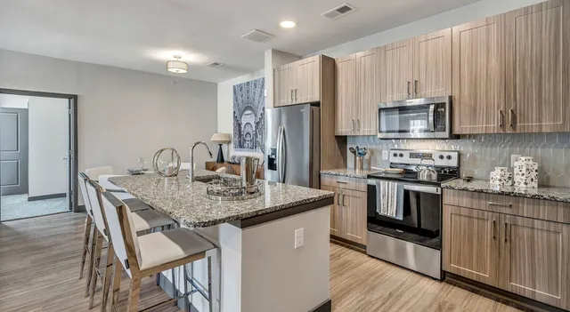 a kitchen with stainless steel appliances granite countertop a kitchen island hardwood floor sink and stove