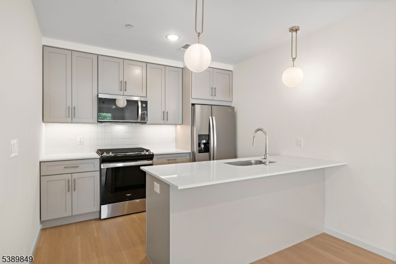 70 Ridgedale Avenue, Unit 207 Morristown, NJ 07960 - Photo 3 of 21 a kitchen with stainless steel appliances granite countertop a sink a stove a refrigerator cabinets and a dining table