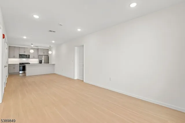 a view of kitchen with kitchen island and stainless steel appliances