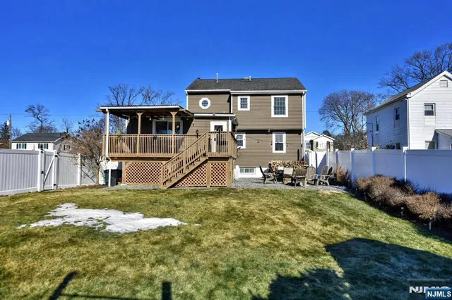 a view of a house with a big yard and large trees