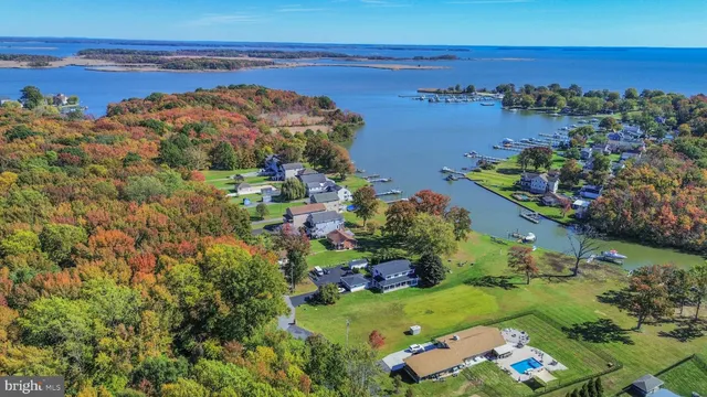 an aerial view of ocean and residential houses with outdoor space
