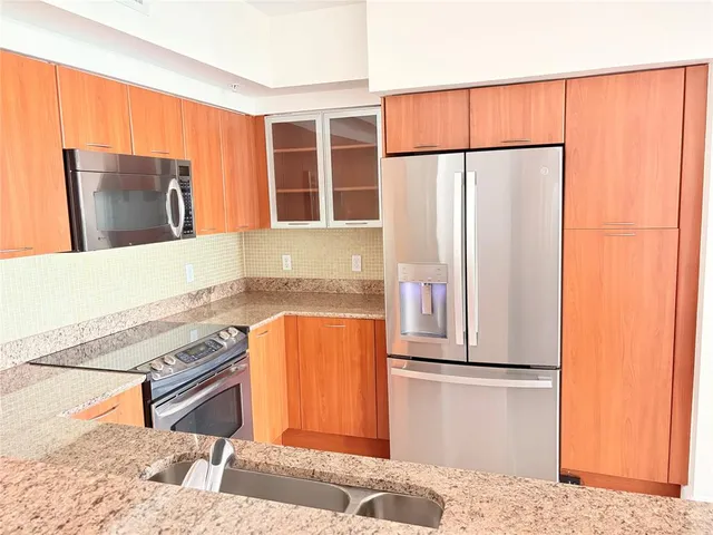 a kitchen with stainless steel appliances granite countertop a refrigerator and a sink