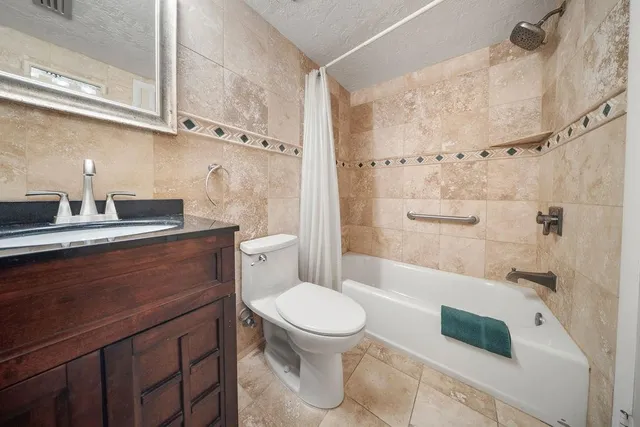 a bedroom with a bed a table and painting on the wall