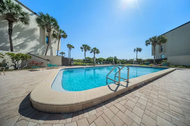 a view of a house with a small yard and a palm tree