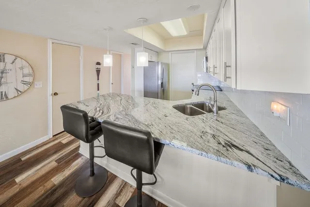 a kitchen with stainless steel appliances granite countertop a refrigerator and a stove top oven