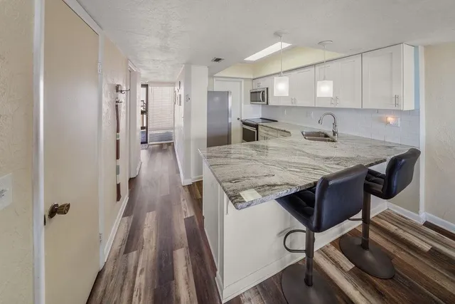 a bed sitting in a kitchen and kitchen with furniture