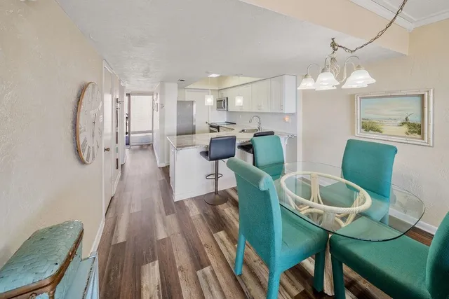a view of a dining room with furniture a chandelier and wooden floor