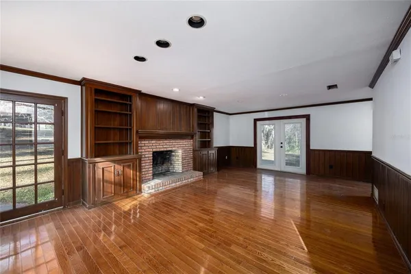 a large white kitchen with a stove a sink a refrigerator and white cabinets