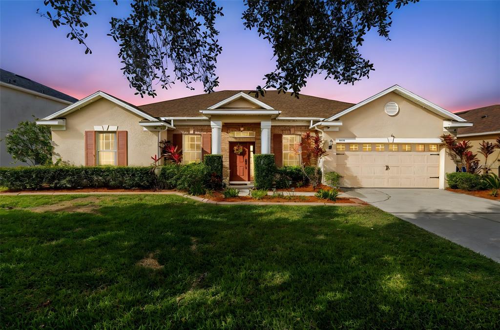 a front view of a house with a garden and yard