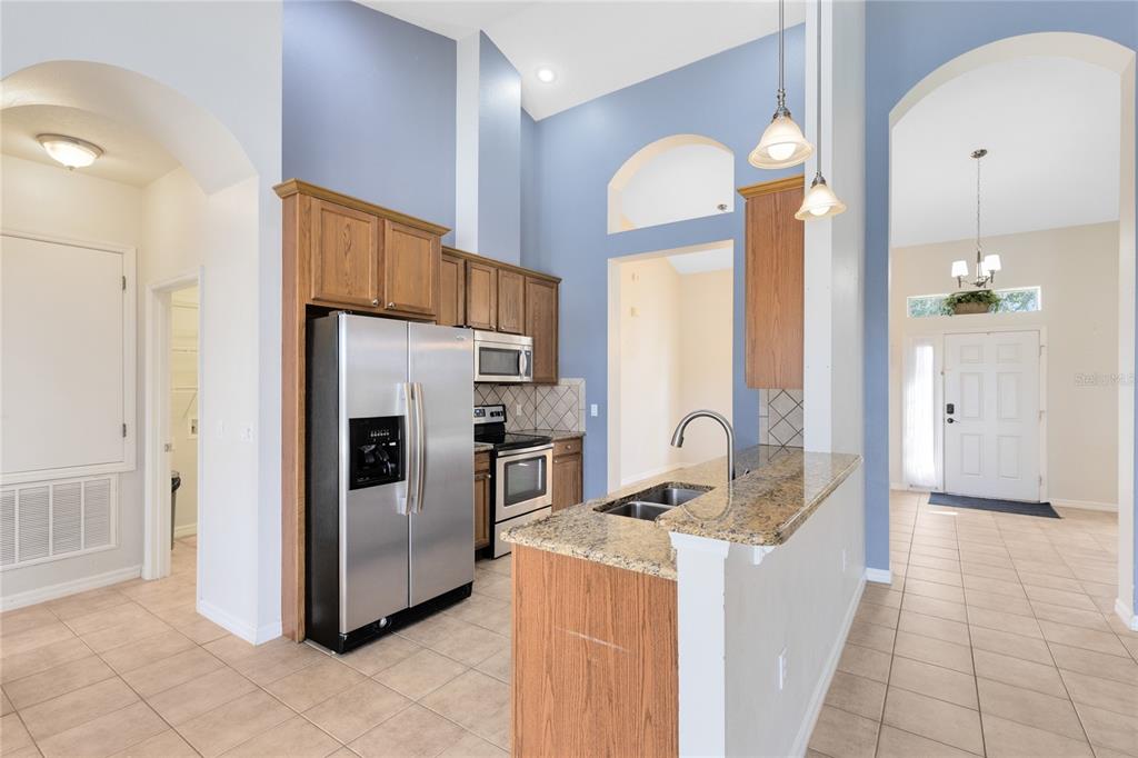3510 Pawleys Loop South St. Cloud, FL 34769 - Photo 6 of 32 a kitchen with granite countertop a refrigerator and a sink