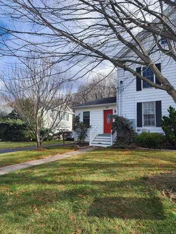 a view of a house with a big yard and large trees