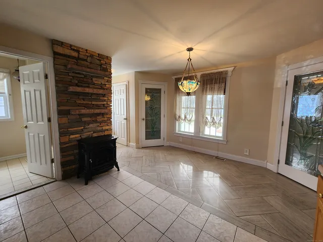 an empty room with fireplace and windows