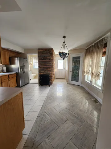 a view of empty room with a fireplace and window