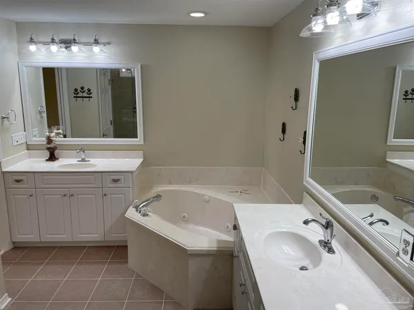 a bathroom with a tub sink and mirror