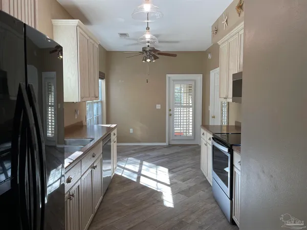 a kitchen with stainless steel appliances granite countertop a refrigerator a stove and a sink